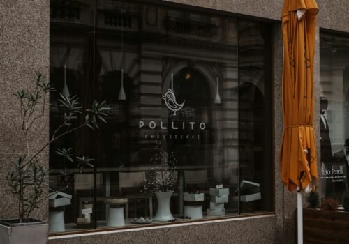 a store front with a yellow umbrella outside of it